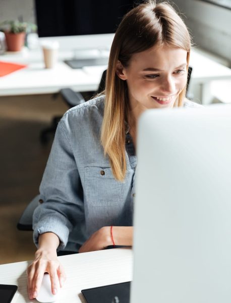 happy-young-woman-work-in-office-using-computer-PERMEN2