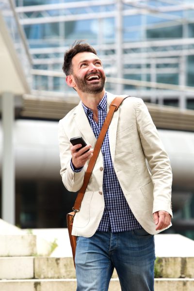 smiling-mature-man-outdoors-with-mobile-phone-PB28ME5